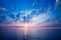 Tranquil Horizon: Serene Ocean Under a Cumulus Sky at Dusk