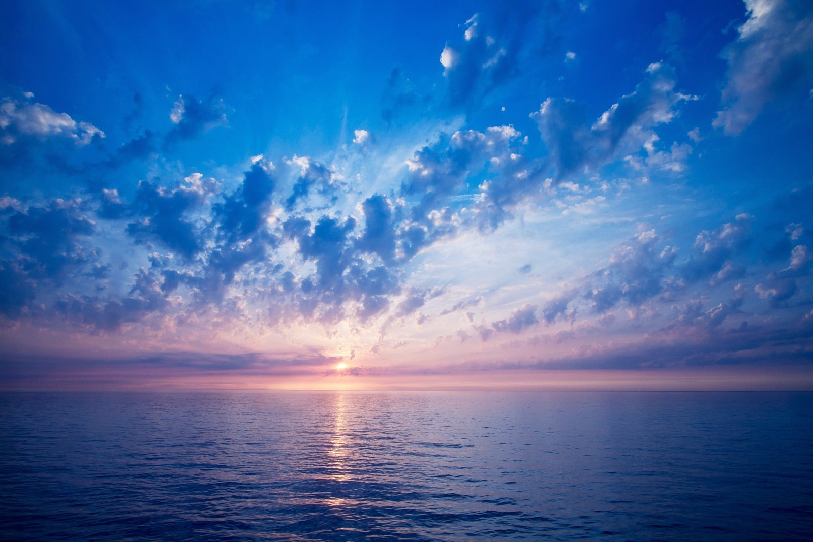 Vue d'un coucher de soleil sur l'océan avec des nuages (horizon, mer, nuage, océan, journée)