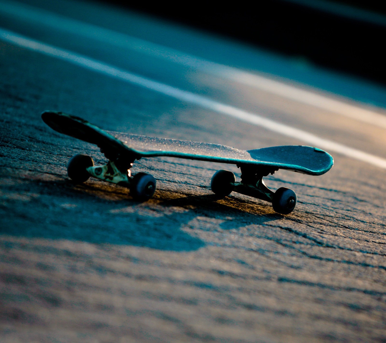 There is a skateboard that is laying on the ground (extreme, skateboard, sport)