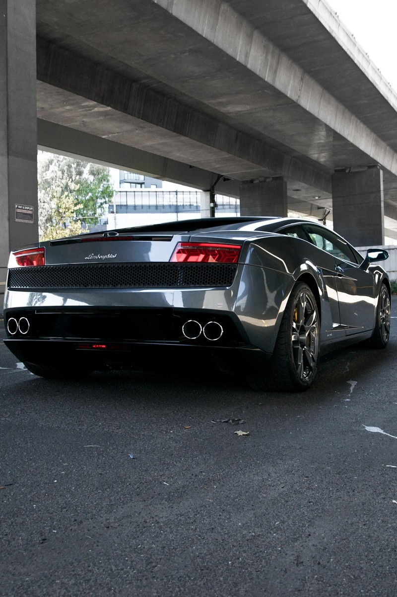 Спортивный автомобиль, припаркованный под мостом на парковке (назад, машина, lamborghini, супер)