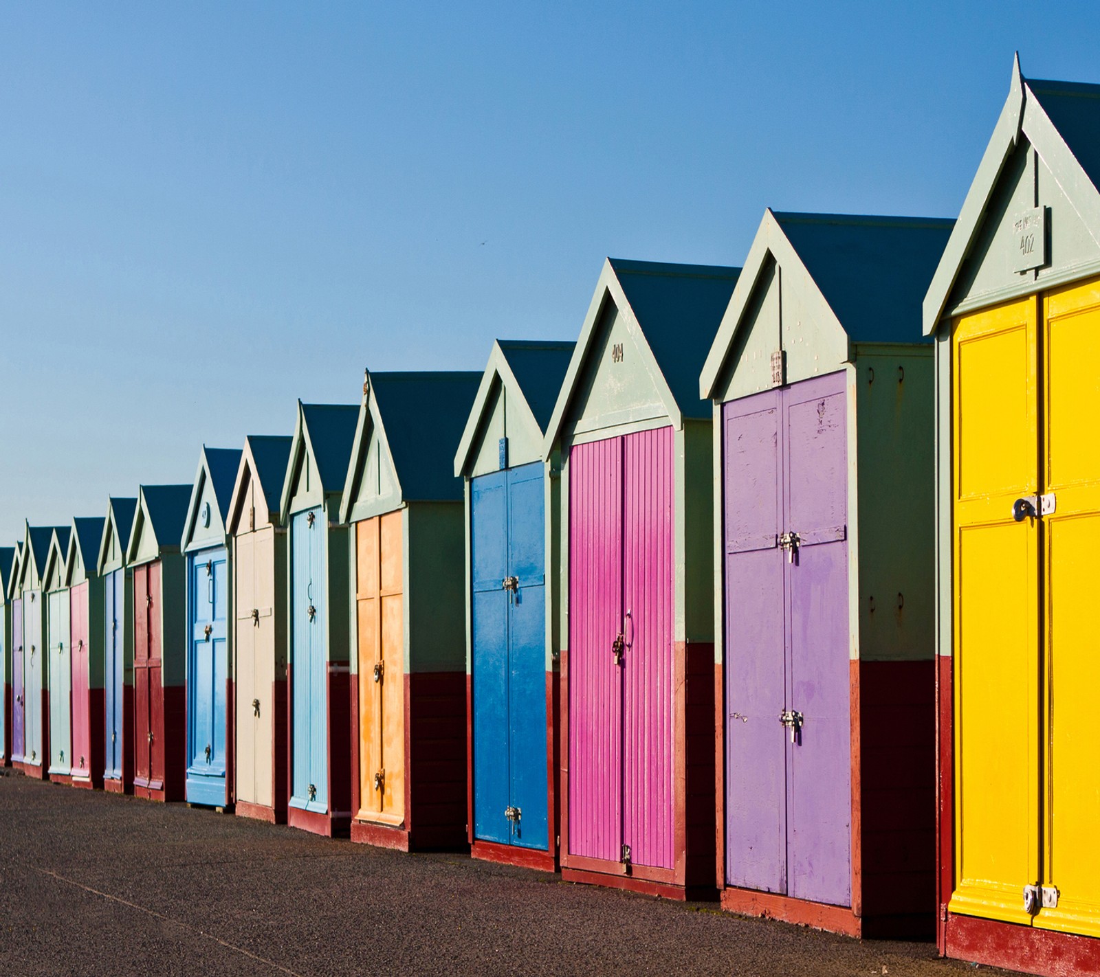 Brightly colored beach huts line the side of a road (2013, sony, sony xperia z)