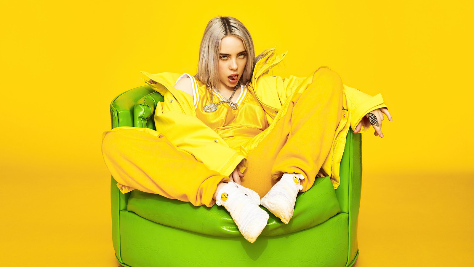 Арафес сидит в зеленом кресле в желтой куртке (billie eilish, американский, певец, знаменитость, девочки)