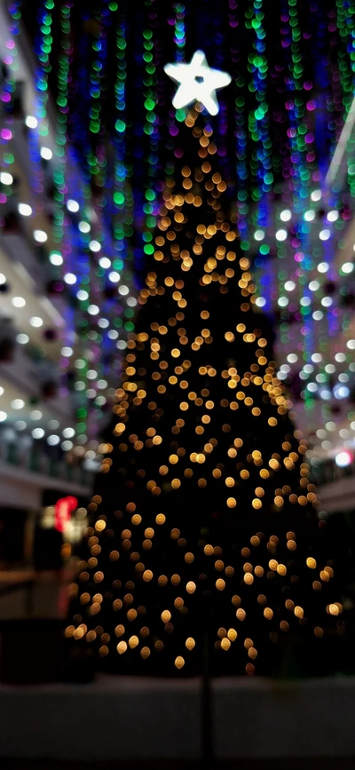 Árbol de Navidad iluminado adornado con luces de colores y una estrella en la cima