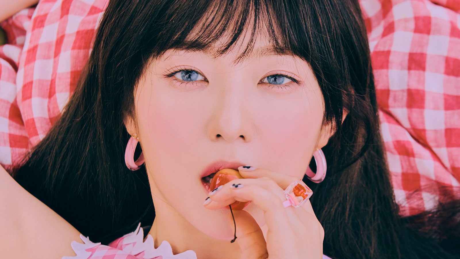 Un primer plano de una mujer comiendo una dona en una cama (red velvet, irene, bae joo hyun, el festival reve día 2, the reve festival day 2)