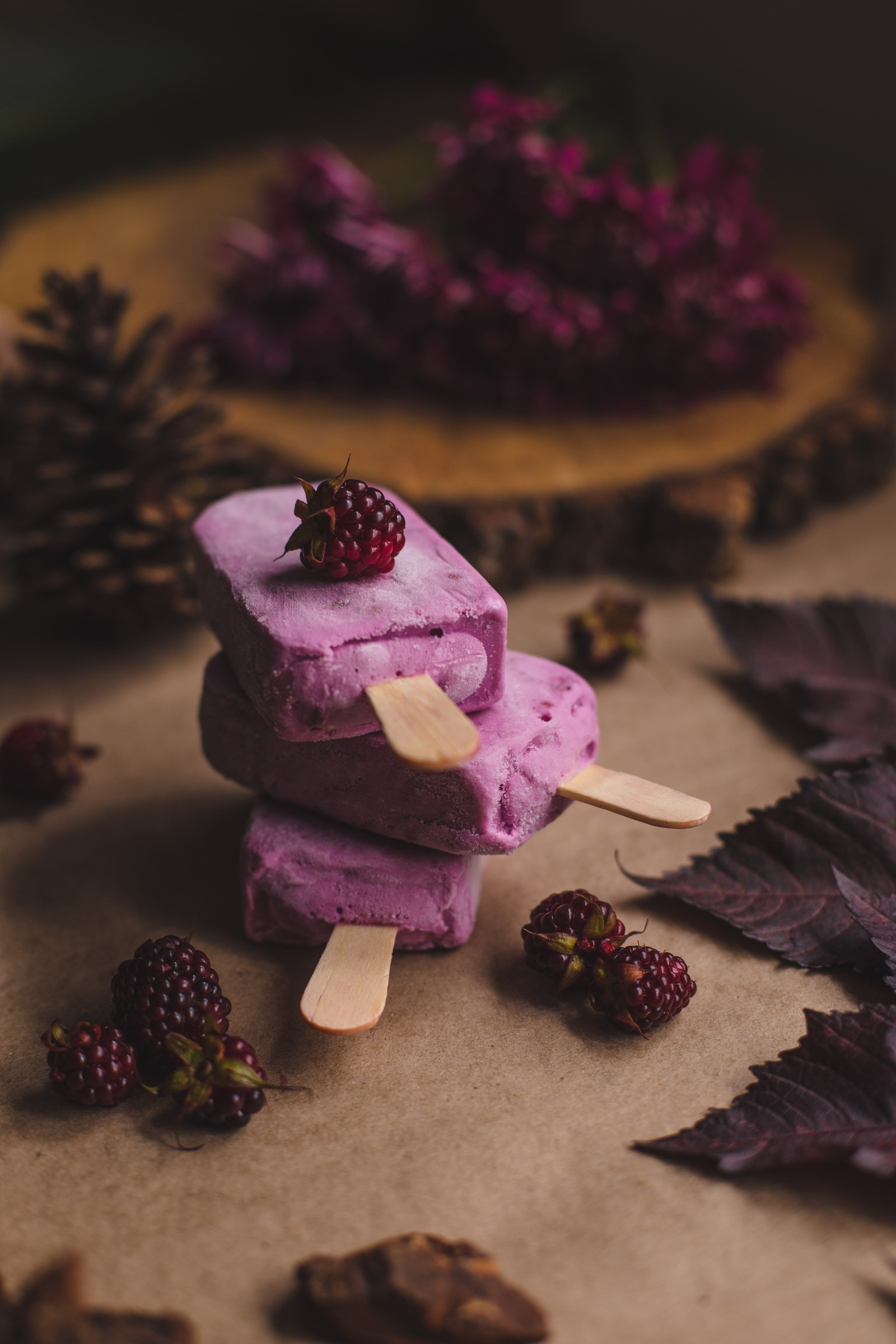 Hay un helado en una mesa con bayas encima (púrpura, comida, dulzura, violeta, petit four)