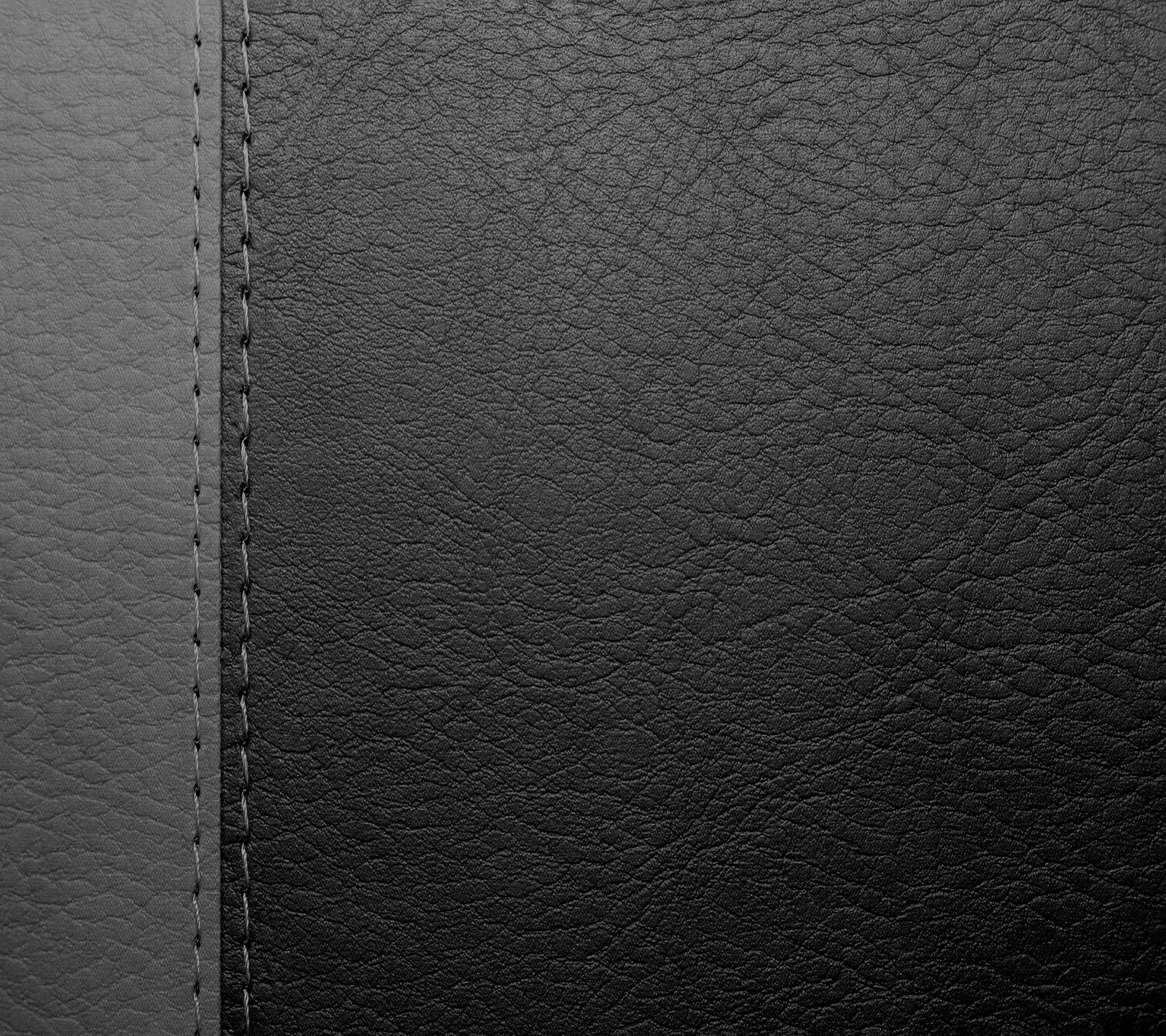 A close up of a black leather texture with a stitching edge (abstract, backgound, black grey leather)