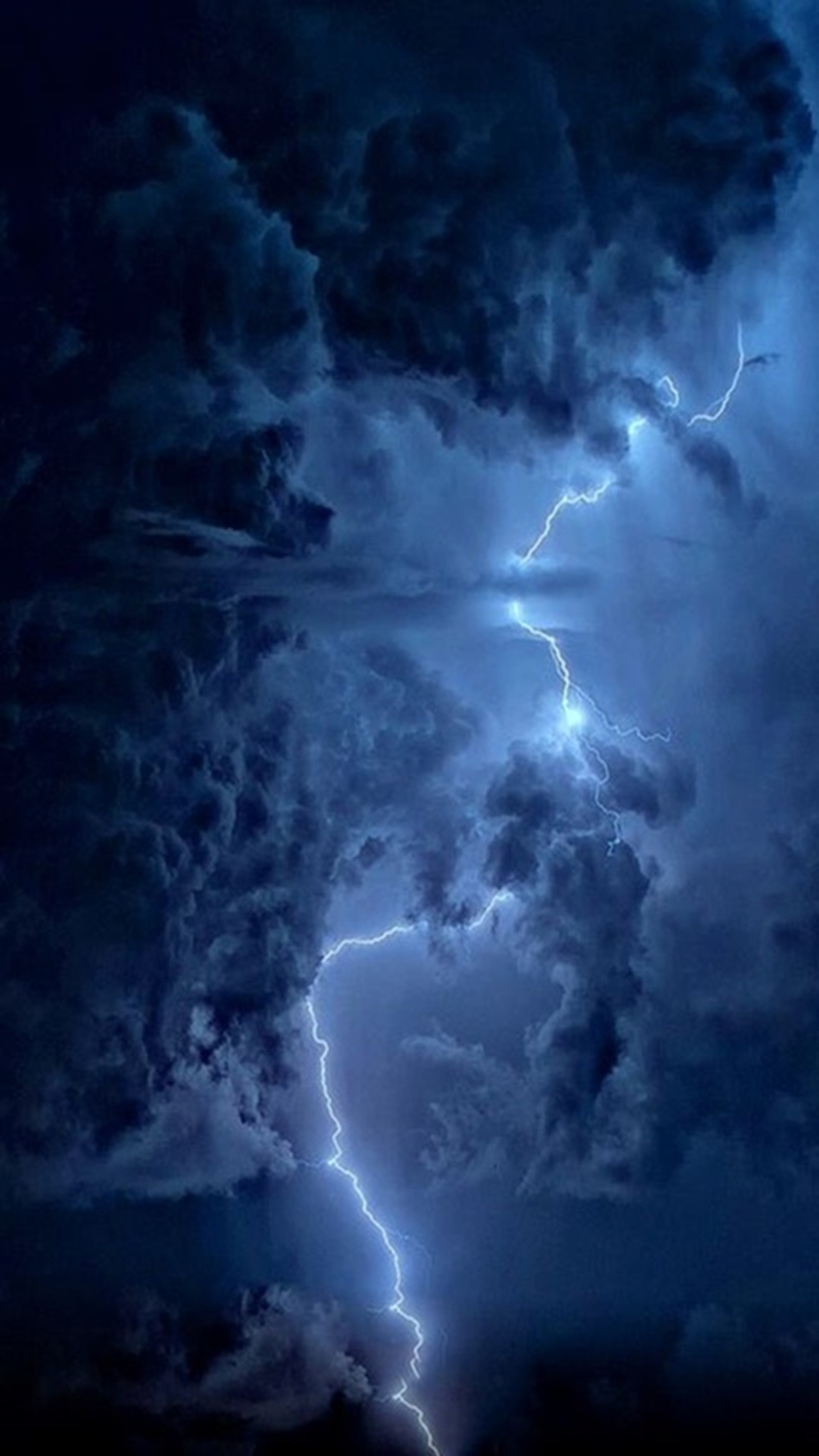 Lightning striking through the clouds in a dark sky with a boat in the foreground (nature, storm)