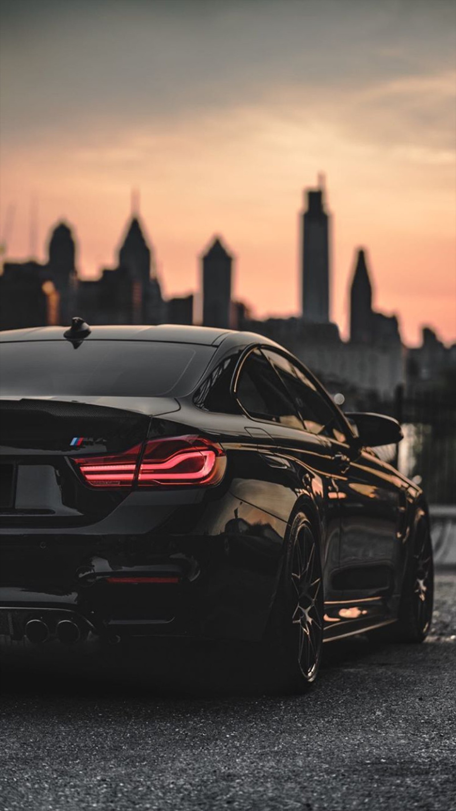 A close up of a black car parked in front of a city (autos, coupe, super, car, supercar)