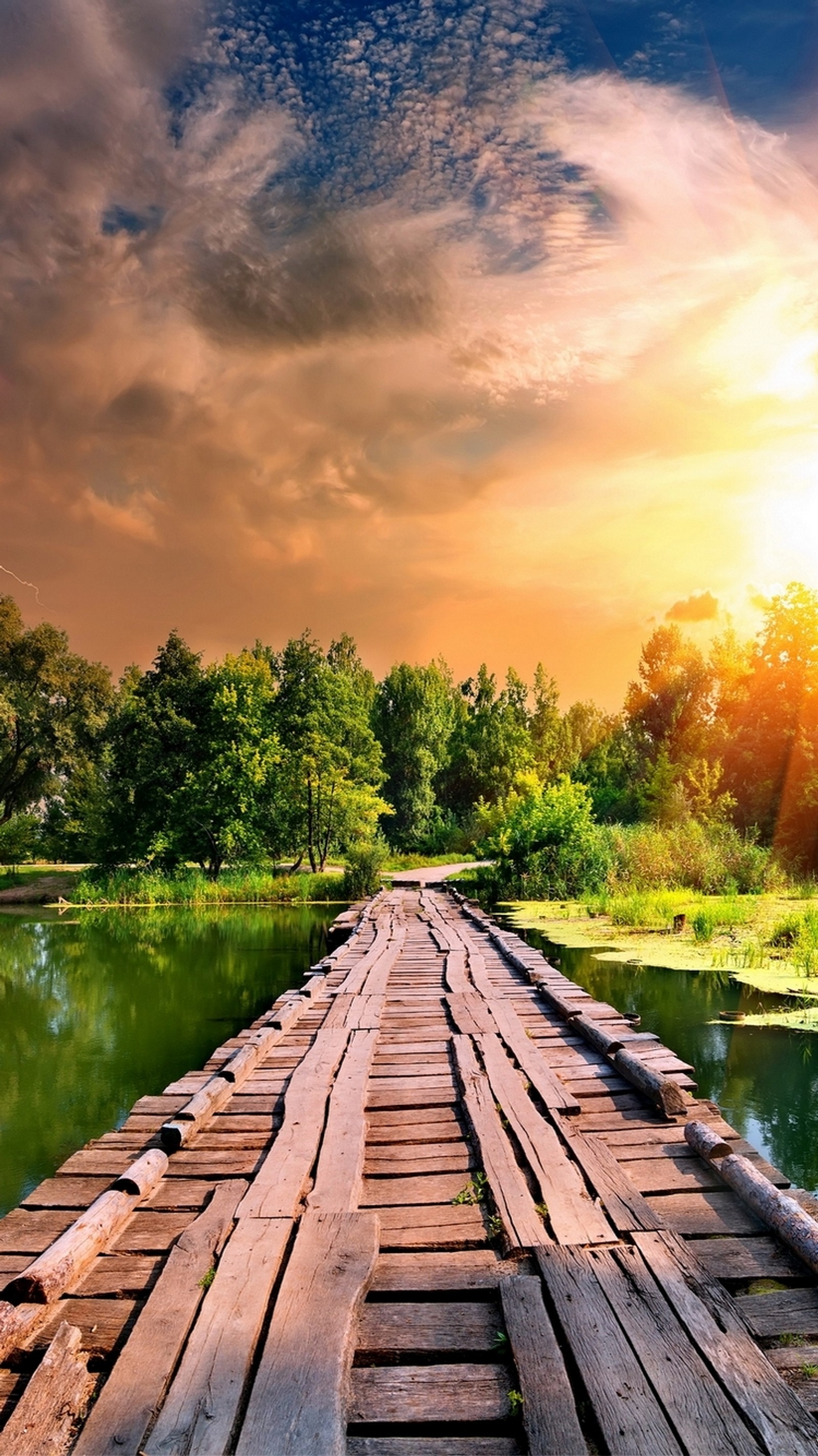 Pont en bois au-dessus d'une rivière avec un coucher de soleil en arrière-plan (génial, beauté, nature, sympa, route)