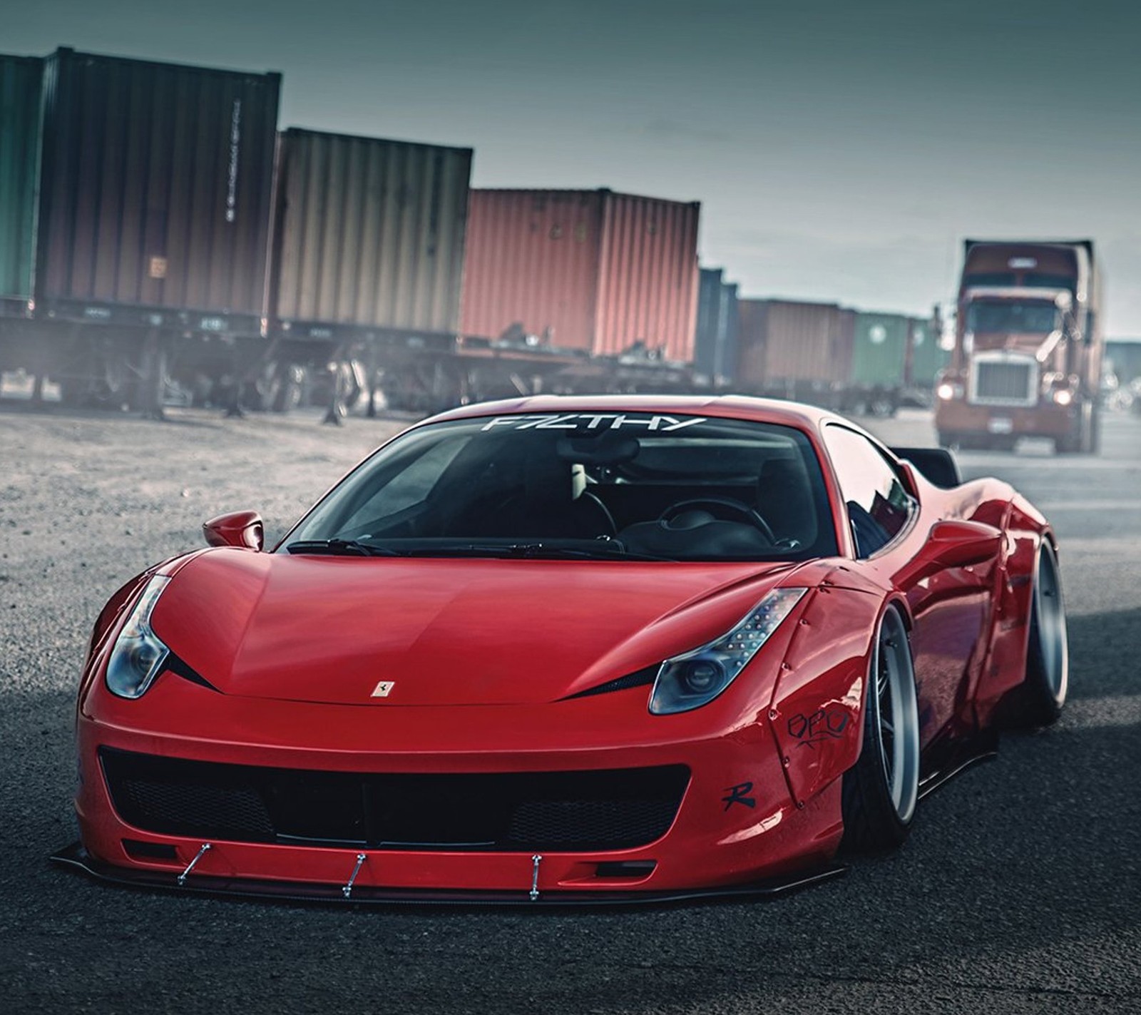 A close up of a red sports car driving on a road (car, ferrari, red)