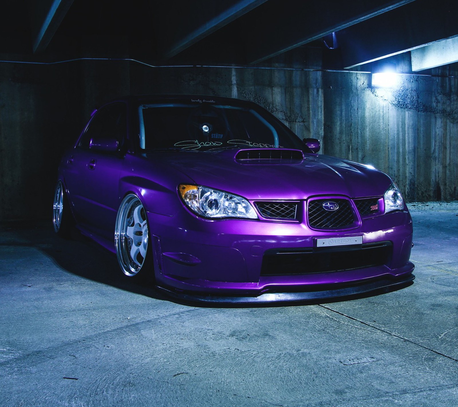 A close up of a purple car parked in a parking garage (car, subaru)