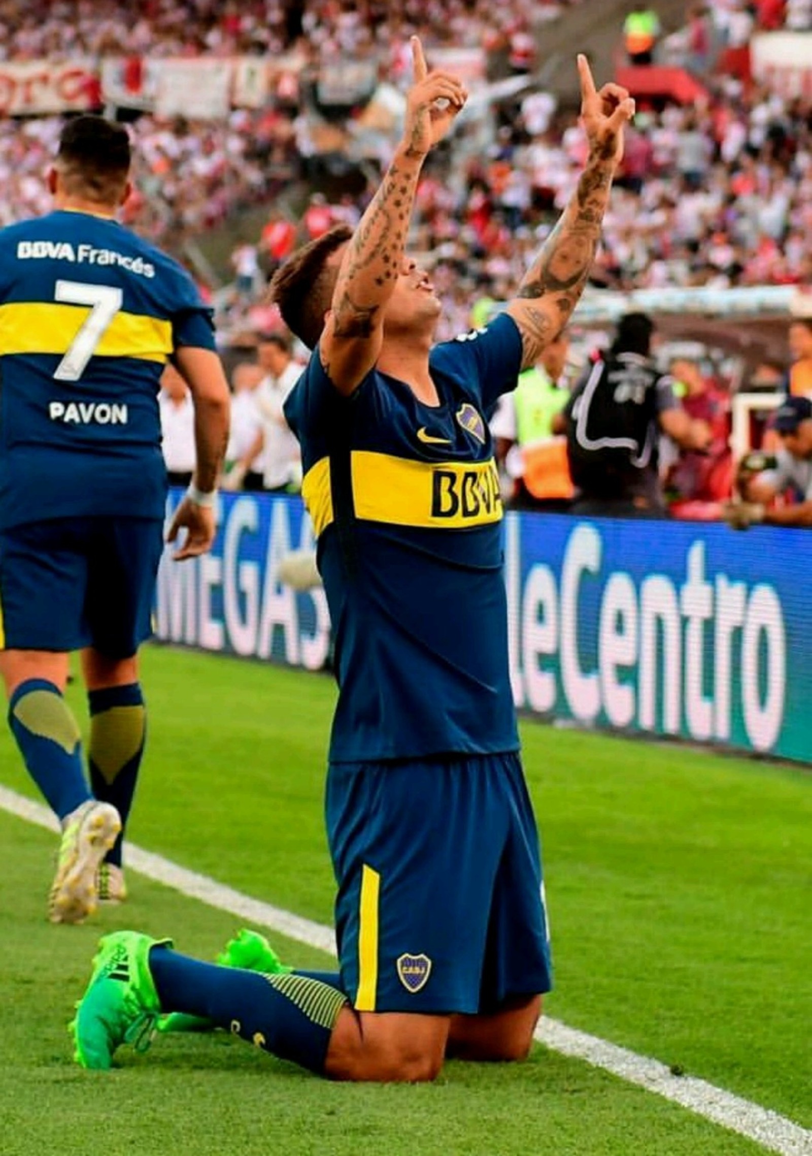 Ein fantasievoller fußballspieler, der auf dem boden sitzt und die hände hebt (boca, boca juniors, cardona, edwin, fußball)