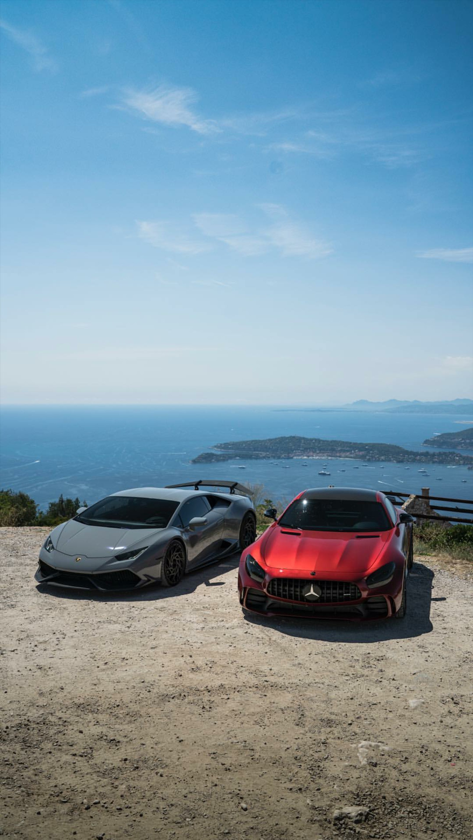 Two cars parked on a dirt road near a body of water (lamborghini, huracan, mercedes, car, supercar)