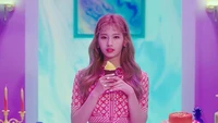 Minatozaki Sana com um cupcake em um cenário colorido de K-Pop