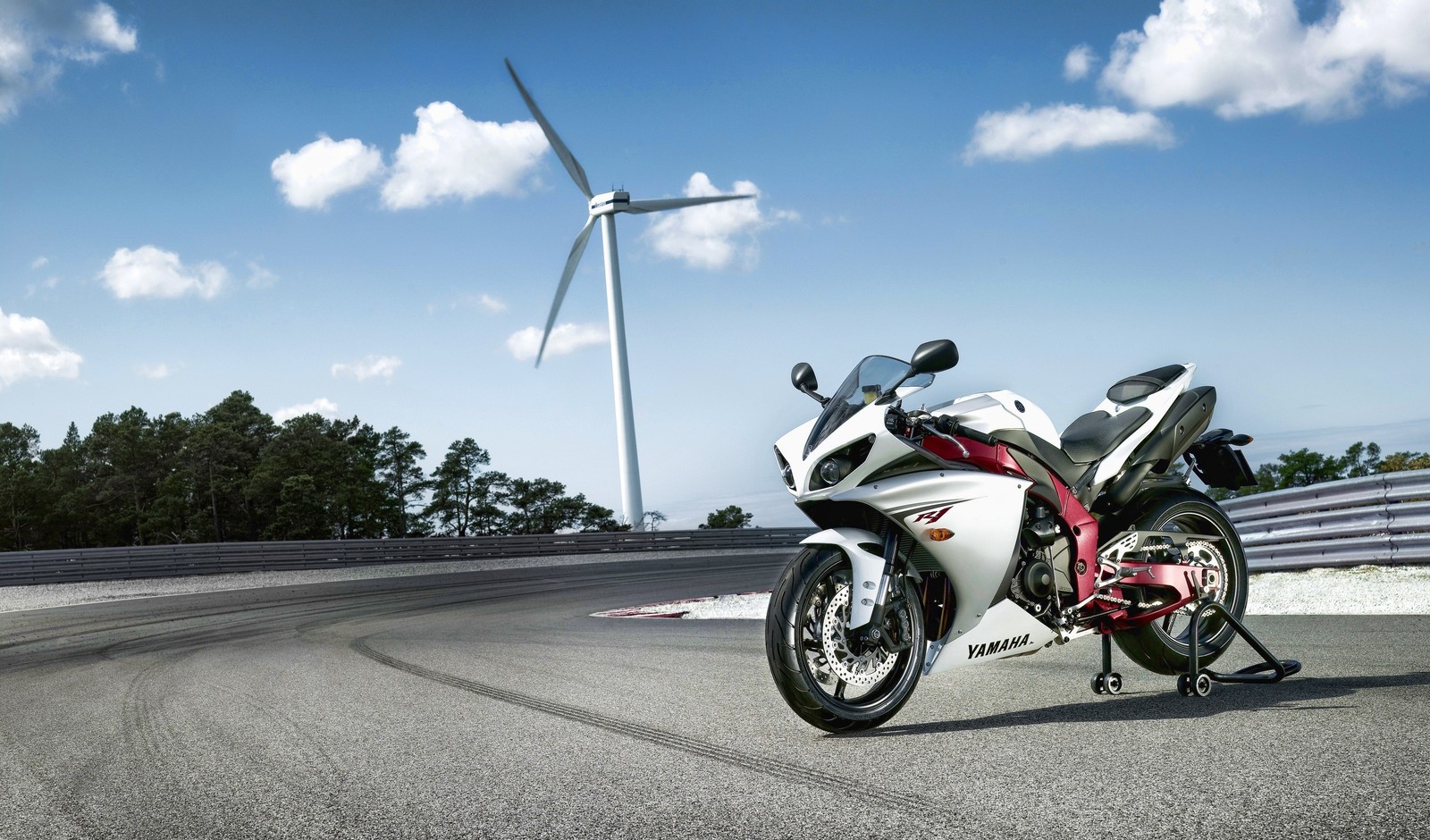 Arafed motorcycle parked on a track with a wind turbine in the background (yamaha motor company, motorcycle, car, motorcycling, road)