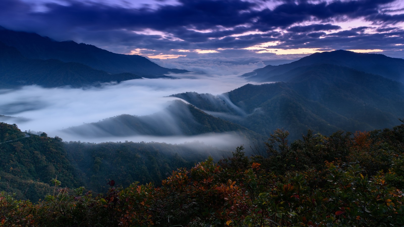 A view of a valley with mountains and clouds in the distance (mountain, scenery, landscape, nature)