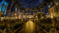 Illuminated Urban Oasis: A Nighttime Cityscape with Reflections and Lush Trees