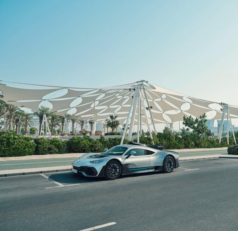 Крупный план серебристого спортивного автомобиля, припаркованного на улице. (mercedes amg one, суперкары, гибридный спортивный автомобиль, концепт кары, машины)