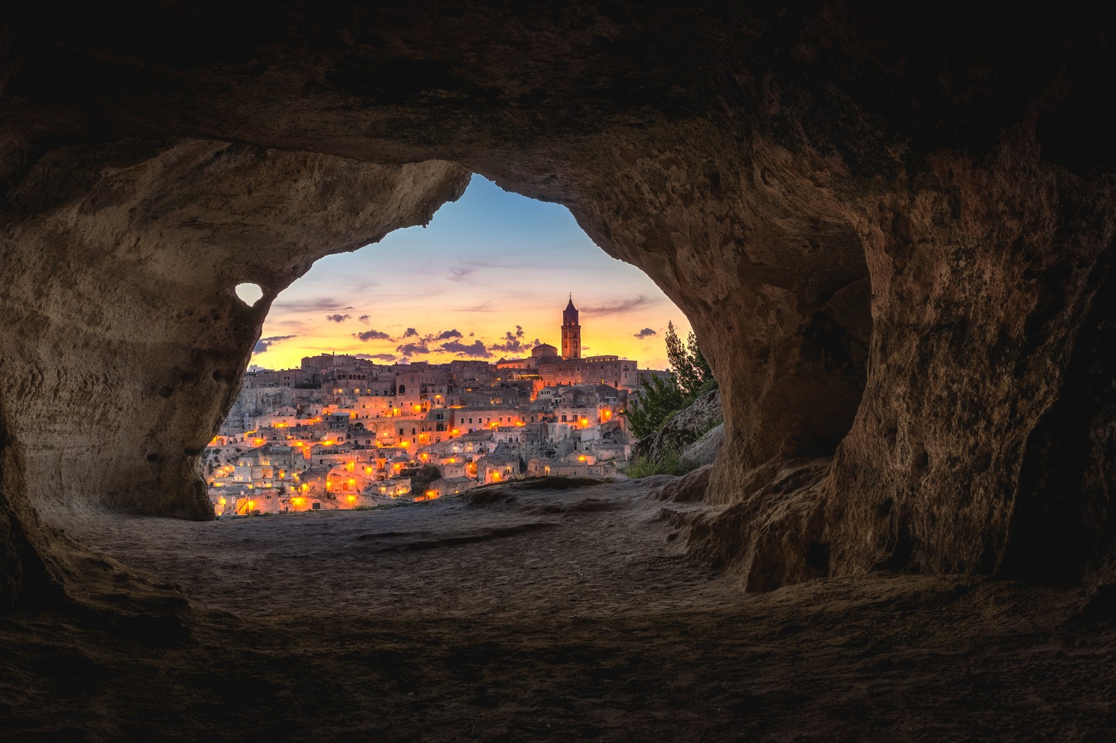 Vue sur la ville depuis une grotte avec vue sur la ville (grotte, voyage, attraction touristique, fenêtre, plante)