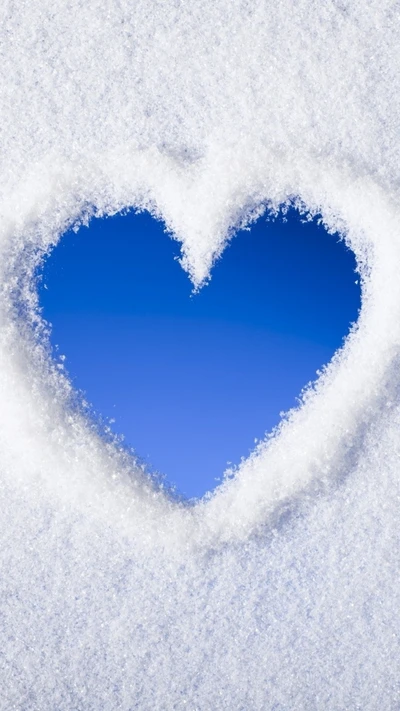 Recorte en forma de corazón en la nieve que revela un cielo azul.