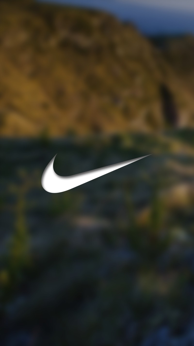 Крупный план белого логотипа nike на размытом фоне (размытие, пейзаж, логотип, гора, природа)