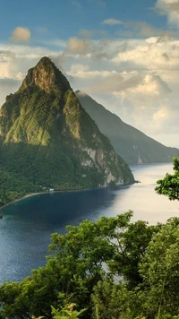 Majestuosa montaña que domina el sereno mar y la exuberante naturaleza