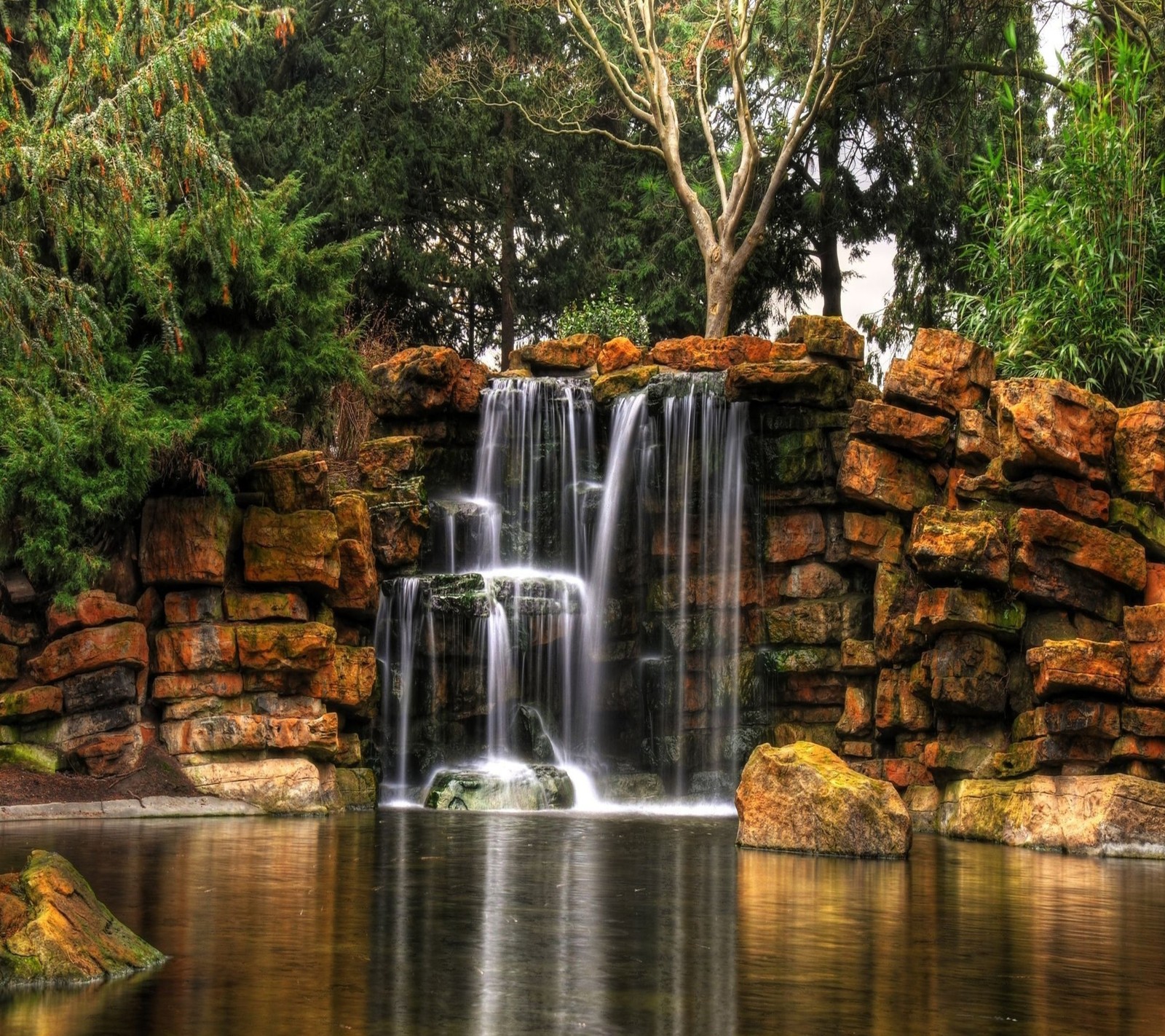 Vista aérea de uma cachoeira em um parque com uma árvore ao fundo (paisagem, natureza, cachoeiras)