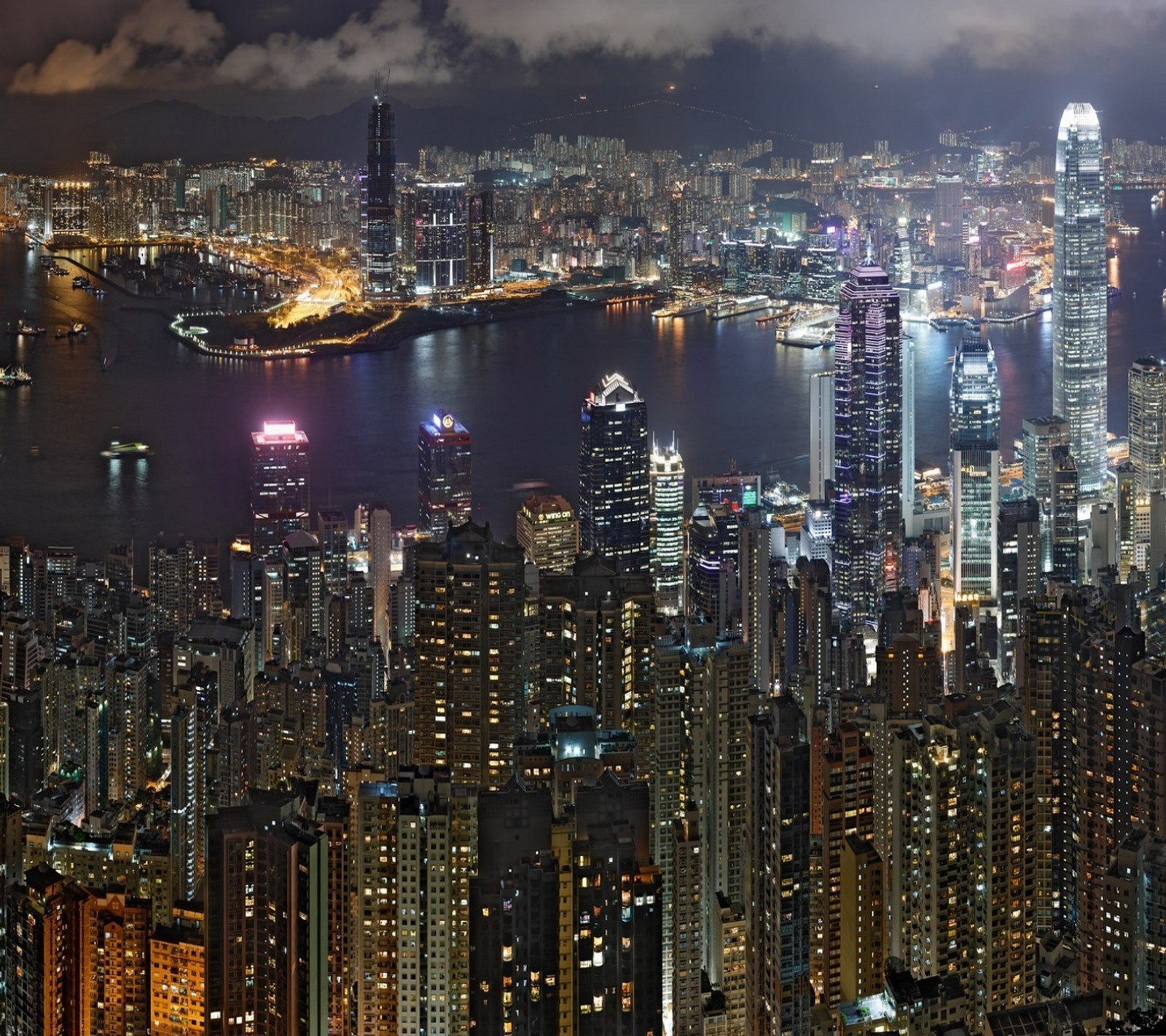 Arafly lit city skyline at night with a river and a boat (city, night)