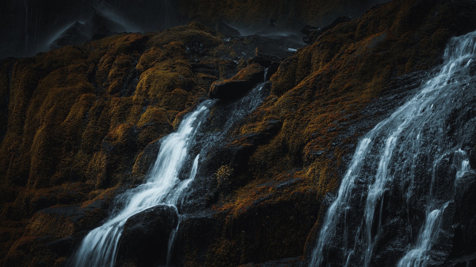 Um close-up de uma cachoeira com um céu escuro ao fundo (cachoeira, água, montanha, paisagem natural, queda)