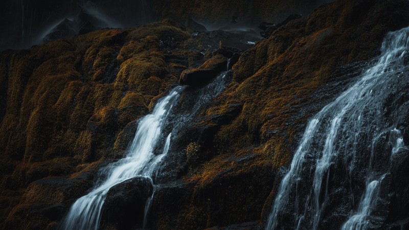 Um close-up de uma cachoeira com um céu escuro ao fundo (cachoeira, água, montanha, paisagem natural, queda)