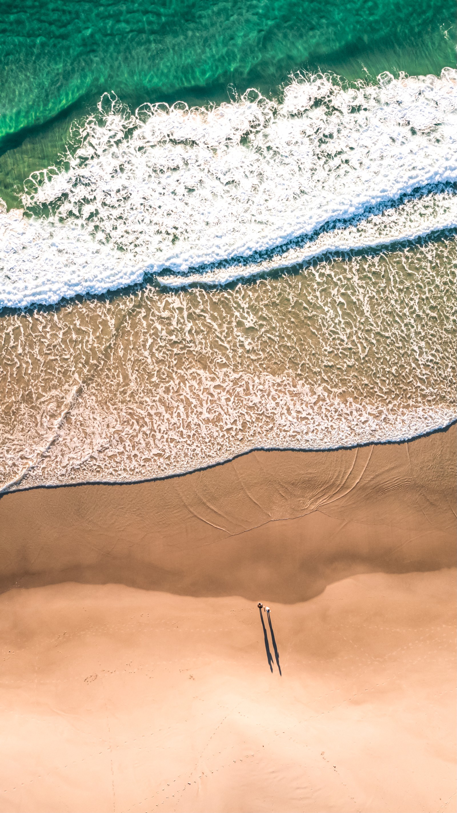 Aerial view of a person on a surfboard on a beach (beach, sand, water, azure, natural environment)