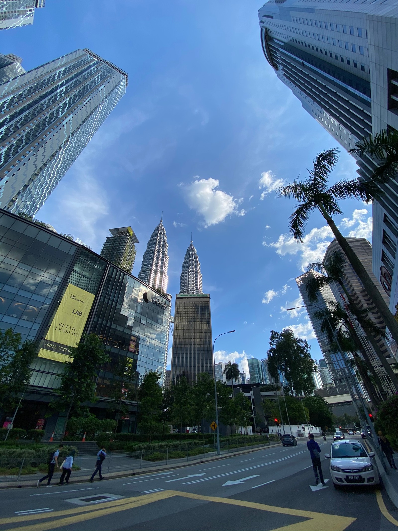 Ansicht einer stadtstraße mit hohen gebäuden und palmen (petronas türme, kuala lumpur, hochhaus, tageszeit, architektur)