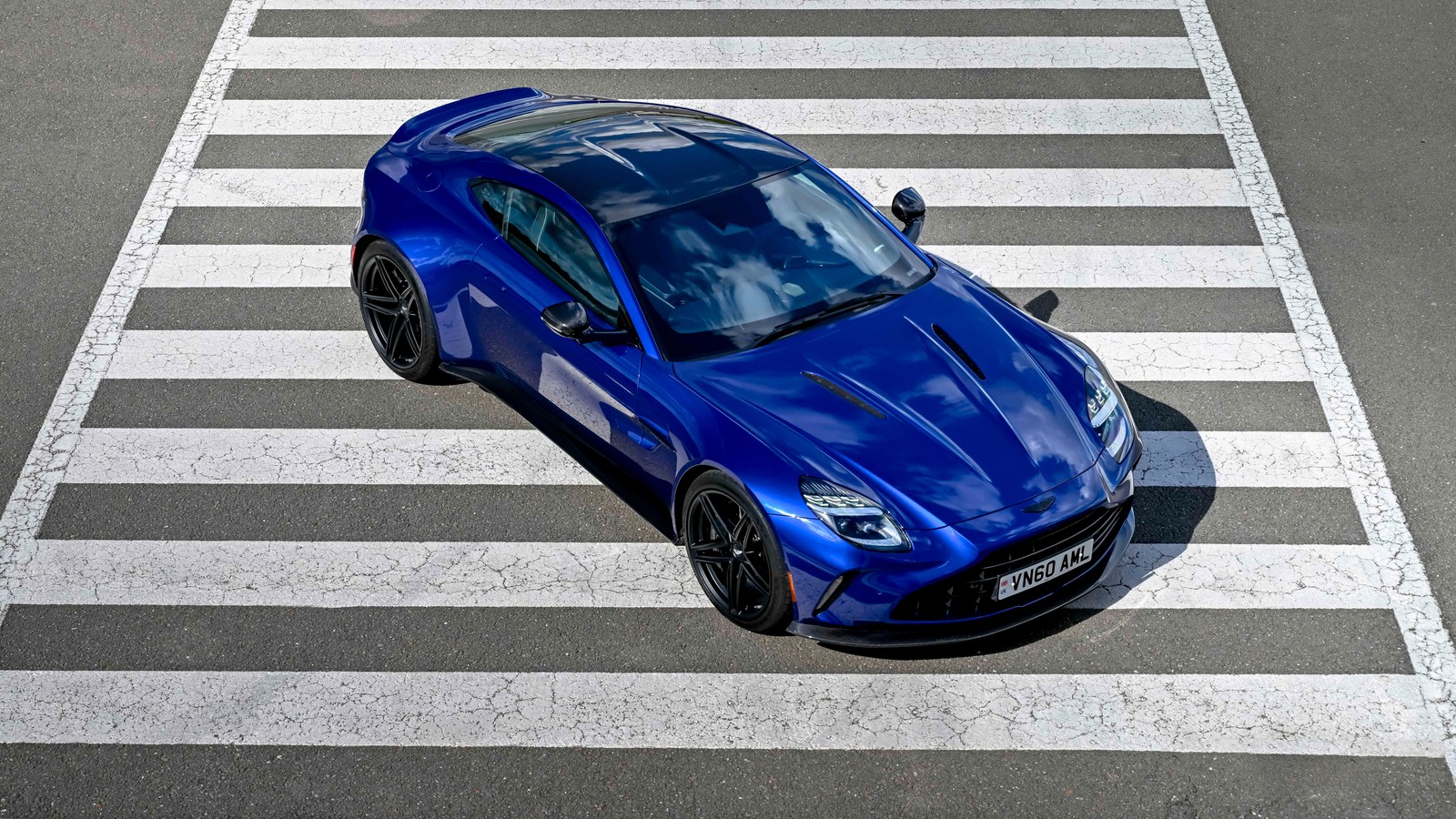 Um close de um carro esportivo azul dirigindo por uma rua (aston martin vantage, 2025, carro esportivo de luxo, 5k, 8k)