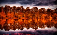 Reflejos de otoño: Un amanecer sereno sobre un lago de tono naranja