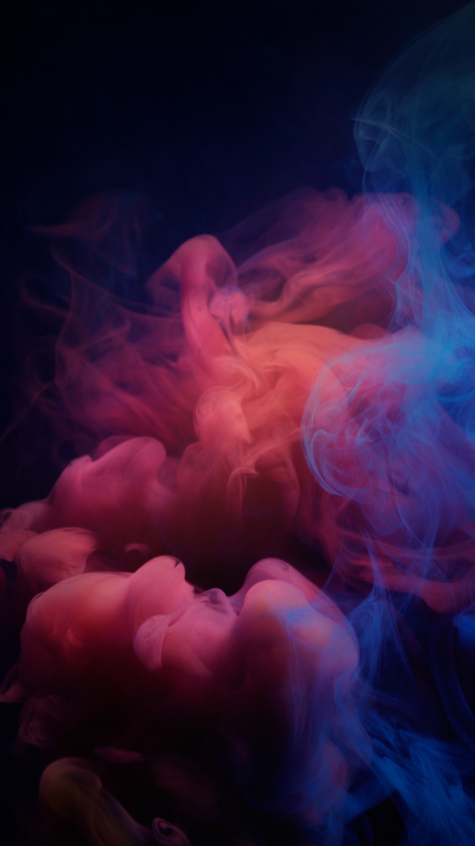 Smoke is swirling in the air with a red and blue background (abstract, colorful, smoke)