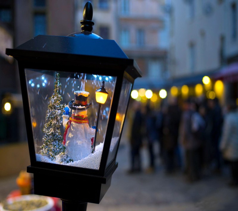 Hay una farola con un muñeco de nieve dentro. (navidad, lámpara, ligero, escena, muñeco de nieve)