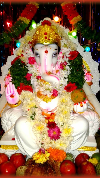 Ídolo vibrante del Señor Ganesh adornado con flores y frutas