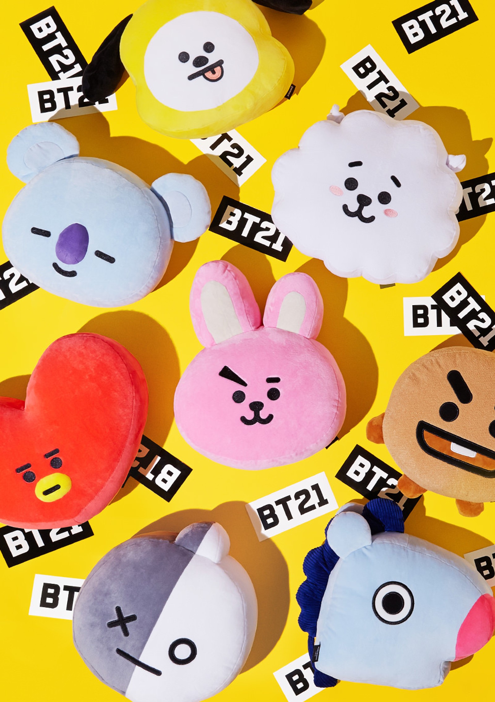 A close up of a bunch of stuffed animals on a yellow surface (bt21, bts, characters)