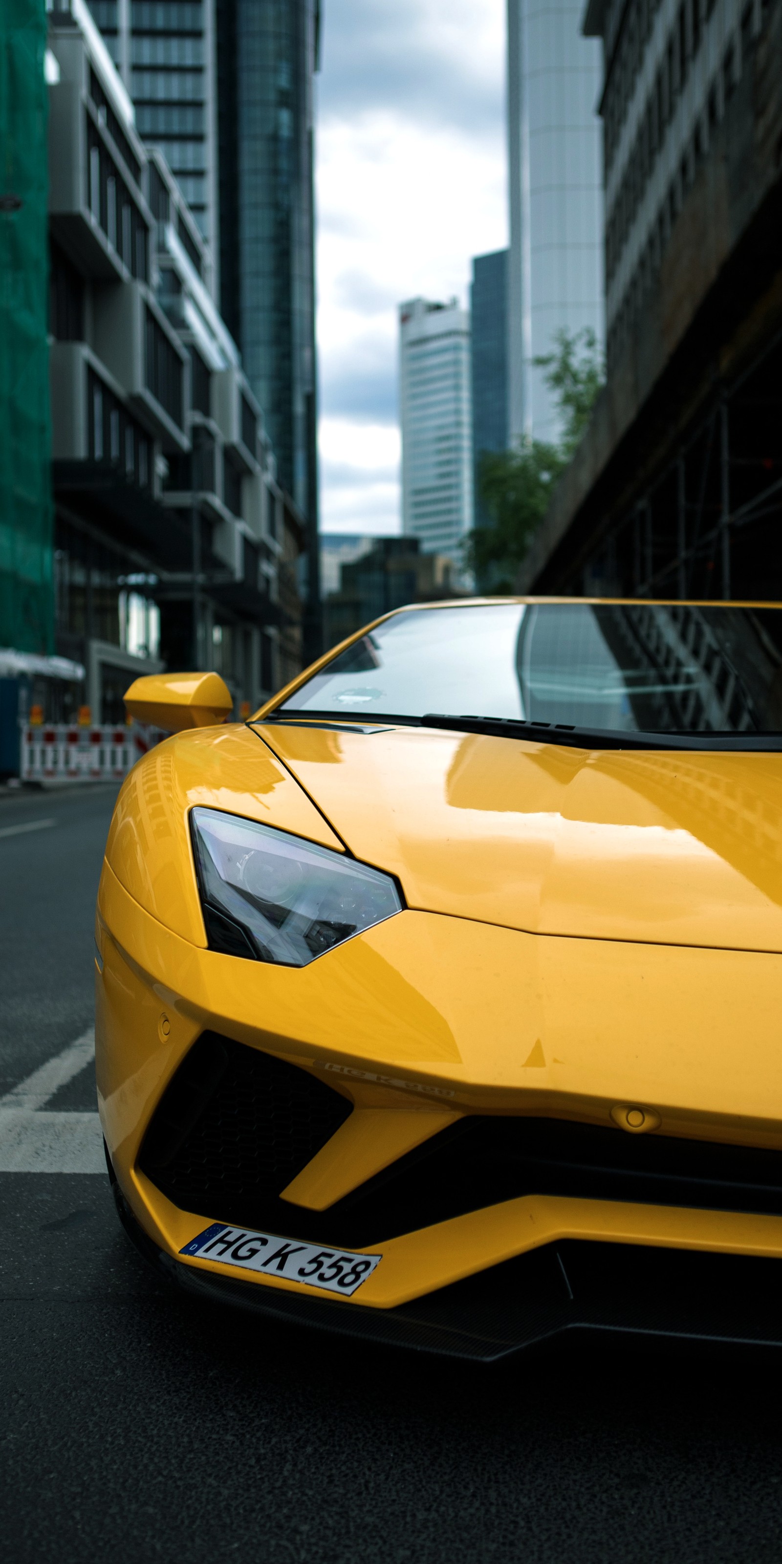 Primer plano de un coche deportivo amarillo estacionado en una calle de la ciudad (lamborghini aventador, lamborghini, coches, ferrari 458, supercoche)