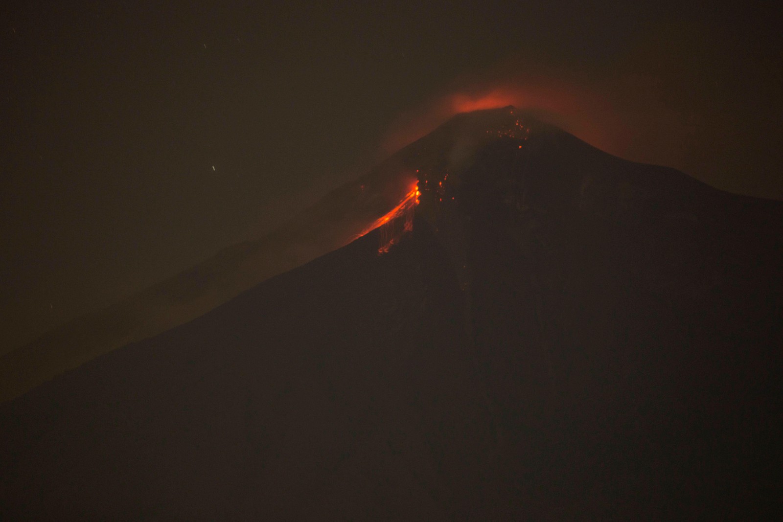 Unscharfes bild eines berges mit einem lavaausbruch und rotem glühen (arten von vulkanausbrüchen, vulkan, lava, vulkanlandschaft, atmosphäre)