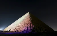 Pirámide de Giza iluminada contra un cielo estrellado