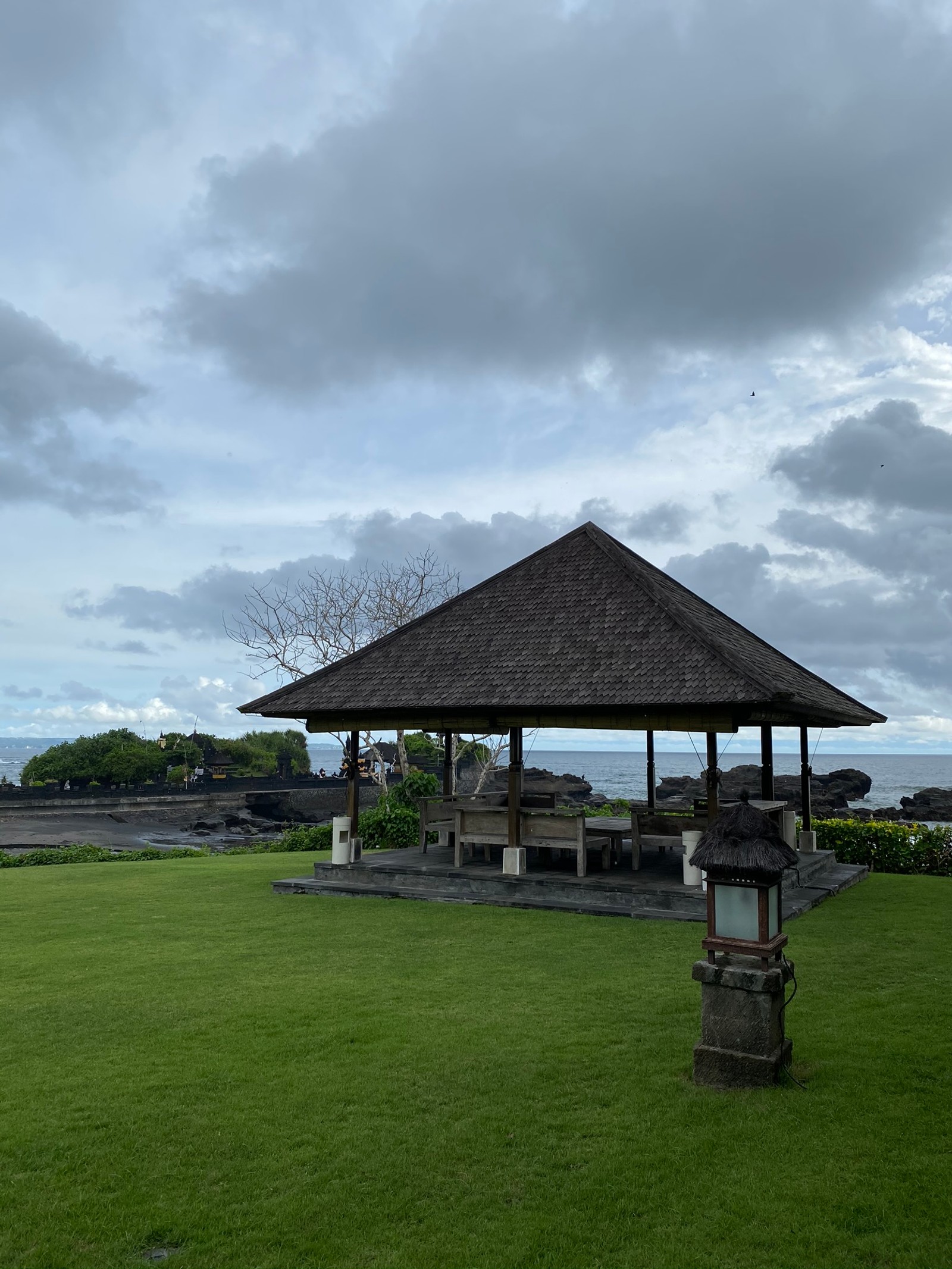 Há um gazebo no meio de um campo gramado (nuvem, terreno, planície, pradaria, sombra)