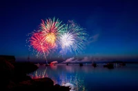 Vibrant Fireworks Display Over Water Celebrating Independence Day