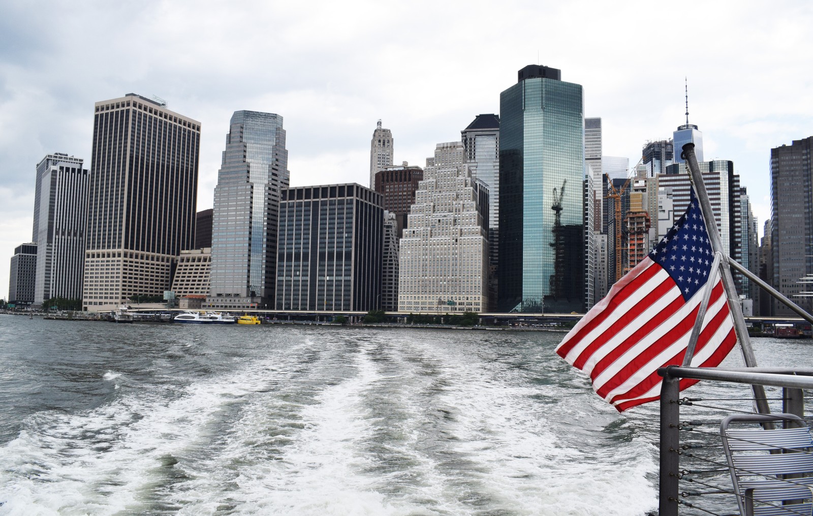 Вид на город с лодки с флагом на ней (нью йорк, new york city, город, горизонт, небоскреб)