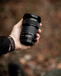 Gros plan d'une main tenant un objectif Canon 24-105 mm