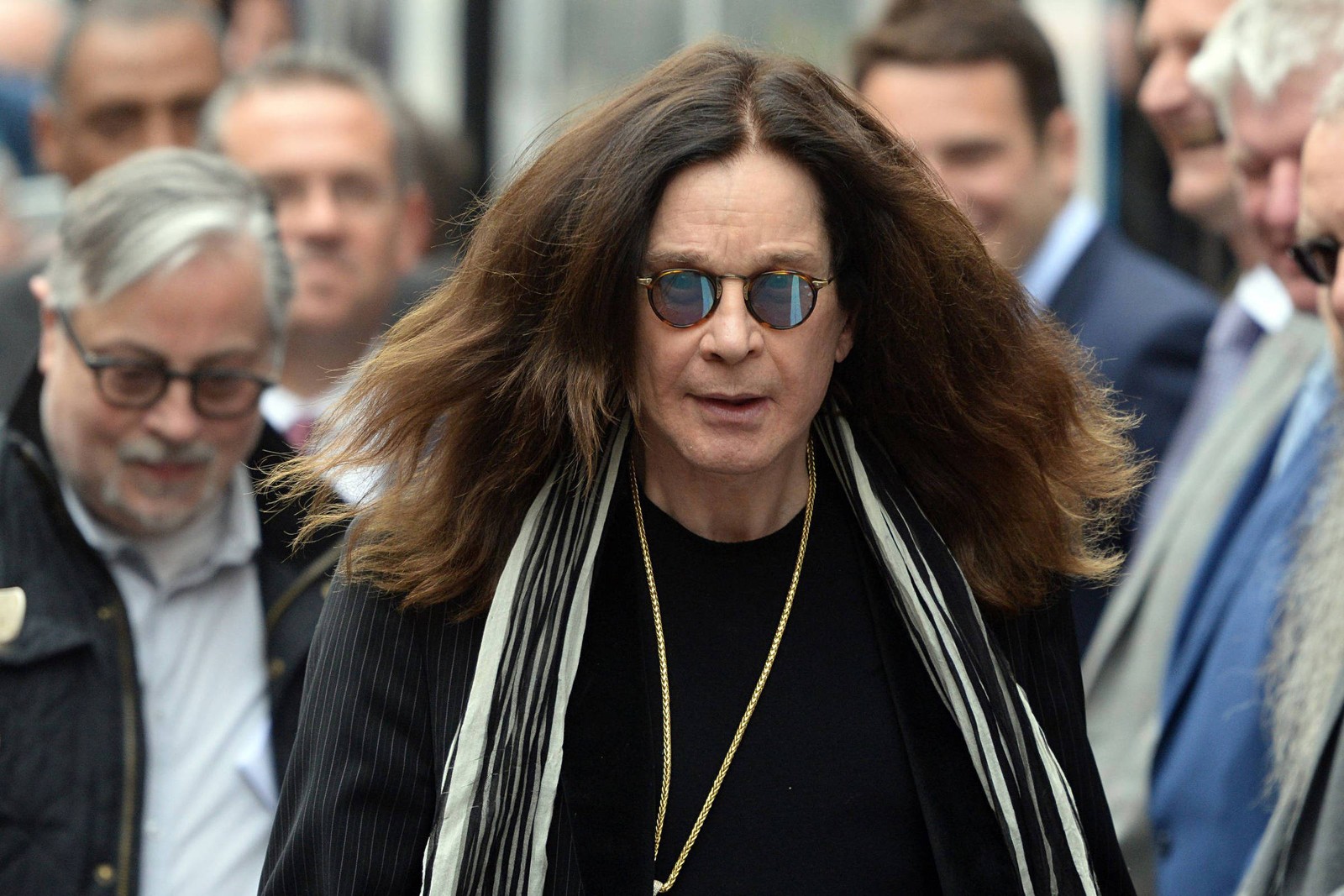 Un gros plan d'une femme aux longs cheveux et portant des lunettes de soleil marchant (lunettes, ozzy osbourne, black sabbath, heavy metal, mode)