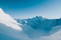 Majestosa cadeia de montanhas cobertas de neve sob um céu azul claro