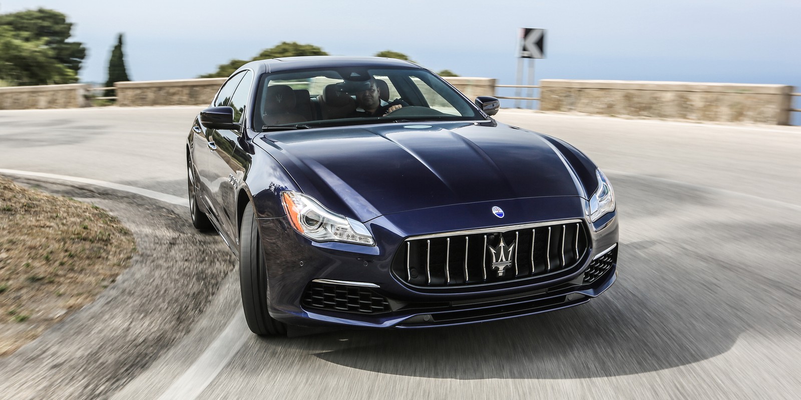 Синий масерати едет по дороге рядом со скалой (масерати грантуризмо, maserati, спортивный автомобиль, машина, седан)