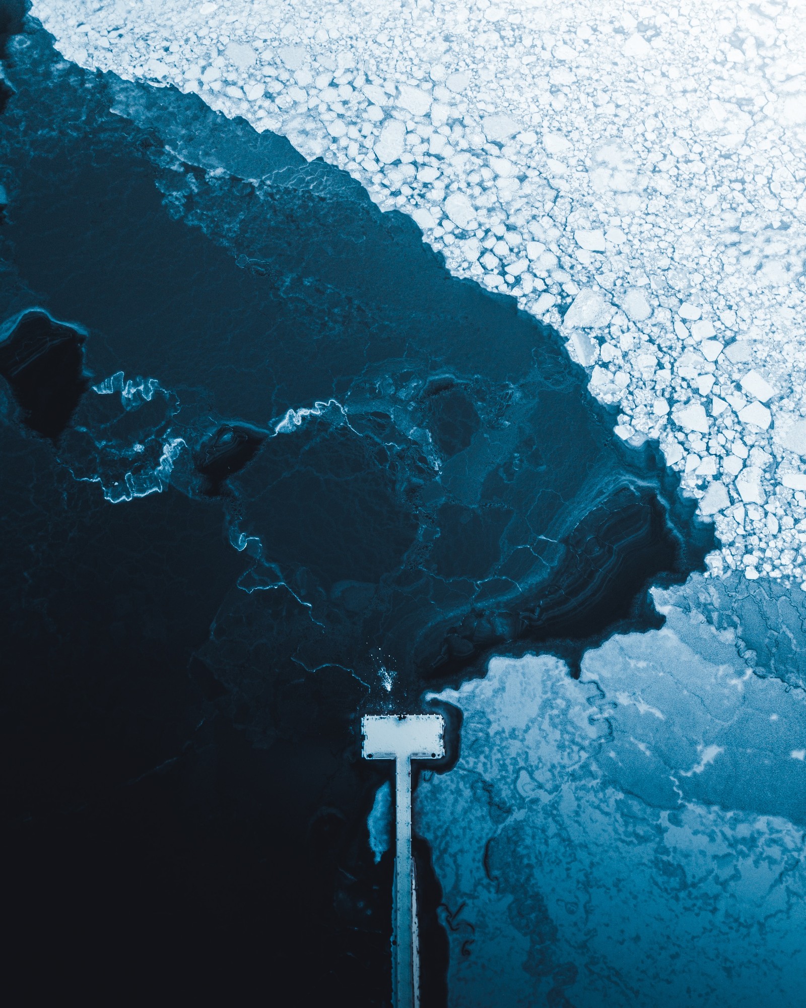 Aerial view of a boat in the water with ice on the water (sea, water resources, ocean, world, sky)