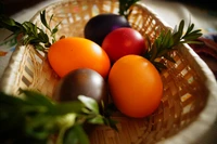 Des œufs de Pâques colorés nichés dans un panier tissé, accentués par de la verdure fraîche, symbolisant les célébrations de vacances et la créativité culinaire.